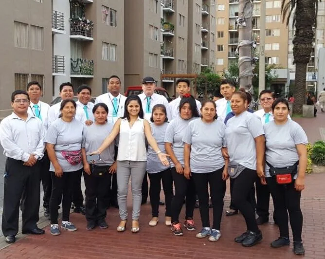 Equipo de Vision & Work: personal de administración, seguridad, limpieza y mantenimiento frente a un edificio residencial